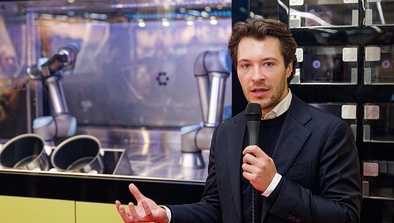 Circus-Gründer Bullwinkel spricht bei der Vorstellung des Kochroboters CA-1 in einem Rewe-Markt. (Archivbild)