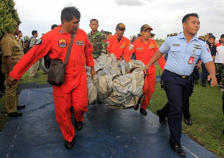 Mitarbeiter der indonesischen Luftwaffe tragen die Notrutscheder abgestürzten AirAsia-Maschine