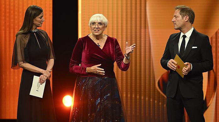 Alexandra Maria Lara (l) und Florian Gallenberger, Präsidenten-Duo der Deutschen Filmakademie, kommen mit Claudia Roth (Bündnis 90/Die Grünen), Staatsministerin für Kultur und Medien, auf die Bühne. Alexandra Maria Lara (l) und Florian Gallenberger, Präsidenten-Duo der Deutschen Filmakademie, kommen mit Claudia Roth (Bündnis 90/Die Grünen), Staatsministerin für Kultur und Medien, auf die Bühne.