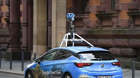 Mit einer auffälligen Kamera auf dem Dach fährt ein Auto von Google Street-View durch das Gerichtsviertel in Frankfurt.
