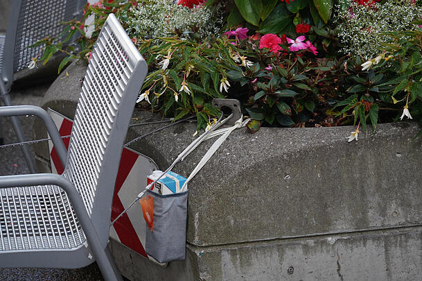 Ein Anzeichen, dass hier doch jemand sa?: Ein Getränkekarton zum Umhängen mit einer Halterrung für Kronkorken. Bleibt nur die Frage: War da wirklich Milch in der Tüte?