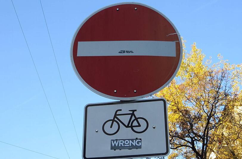 An der Kreuzung Kaiser- und Wilhelmstraße dürfen Radler entgegen der Fahrtrichtung fahren. Das entscheidende Wort "frei" hat jemand allerdings mit "wrong" überklebt.
