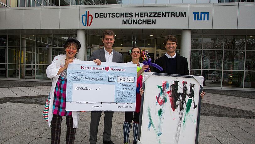 Robert Ketterer und Bernd Sacher übergeben den Scheck an die gutgelaunten Klinikclowns. Daneben steht das Bild, das Mangala gemalt hat. Robert Ketterer und Bernd Sacher übergeben den Scheck an die gutgelaunten Klinikclowns. Daneben steht das Bild, das Mangala gemalt hat.