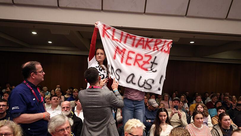 Klimaaktivisten st&ouml;ren mehrere Minuten lang die Podiumsdiskussion mit Merz.
