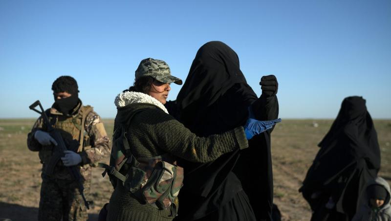 Eine Frau wird von einer Soldatin in einem Kontrollbereich der SDF durchsucht, nachdem sie aus dem verbliebenen Gebiet des IS evakuiert wurde. Eine Frau wird von einer Soldatin in einem Kontrollbereich der SDF durchsucht, nachdem sie aus dem verbliebenen Gebiet des IS evakuiert wurde.