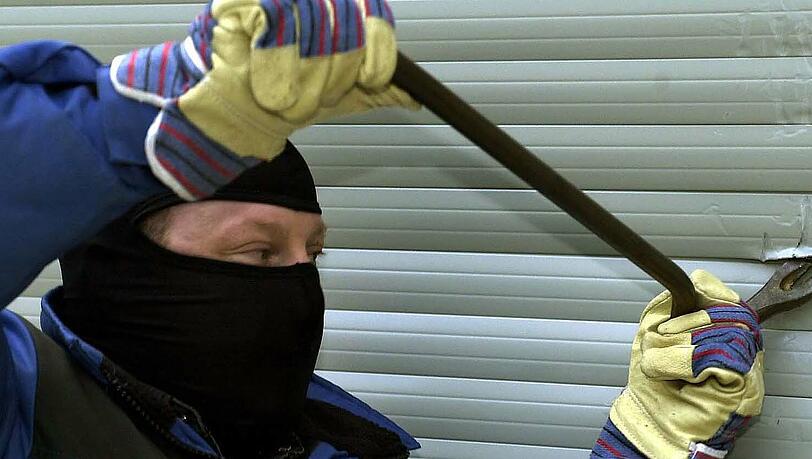 Ein Einbrecher mit einem Stemmeisen (gestelltes Bild). Ein Einbrecher mit einem Stemmeisen (gestelltes Bild).
