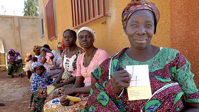 Sie warten vor dem Haus des Vereins Nala in Burkina Faso auf die ärztliche Untersuchung. Jede Frau hat eine Nummer gezogen.