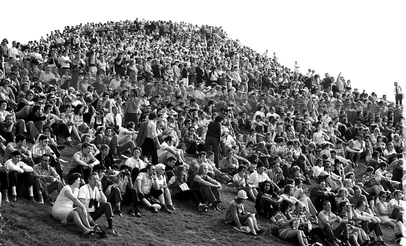 26. August 1972: Von der voll besetzten Kuppe des Olympiabergs lauschen und spähen (auch mit Ferngläsern) die Münchner der Eröffnungsfeier im Olympiastadion.