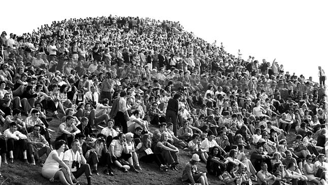 26. August 1972: Von der voll besetzten Kuppe des Olympiabergs lauschen und spähen (auch mit Ferngläsern) die Münchner der Eröffnungsfeier im Olympiastadion.