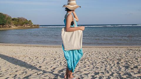 Diese Frau macht es genau richtig: Für den Strand wählte sie ein weites Maxikleid, Schlapphut und Flipflops.