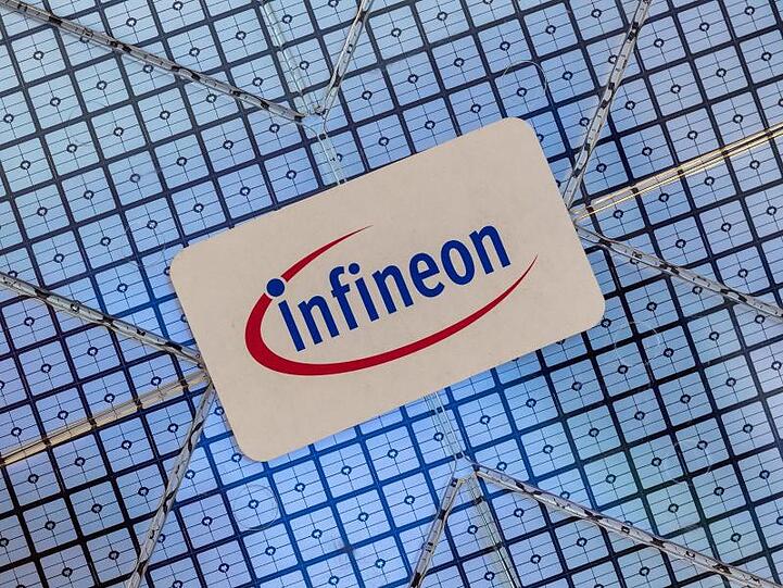 Das Infineon-Logo klebt auf einem Wafer im Showroom des Unternehmens. Foto: Peter Kneffel/dpa/Archivbild