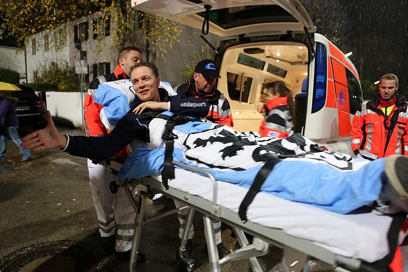 Olaf Bodden wird auf einem Krankenbett auf den Rasen des Grünwalder Stadions gefahren.