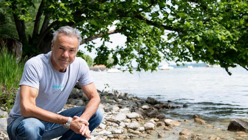 Hannes Jaenicke hockt am Ufer des Ammersees. Hannes Jaenicke hockt am Ufer des Ammersees.