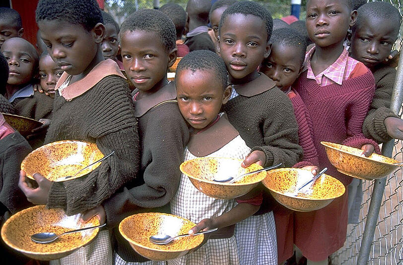 Warten auf eine Mahlzeit: Diese Kinder in einer Grundschule in der Nähe von Harare, der Hauptstadt Simbabwes, erhalten mit Hilfe von UNICEF zumindest ein Mal täglich etwas zu essen.