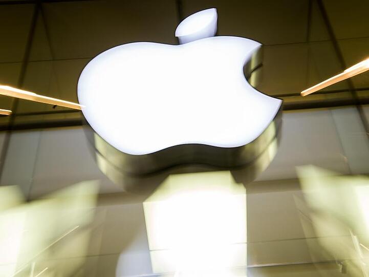 Das Apple-Logo leuchtet an der Fassade des Apple-Store in München. Die EU-Kommission hat gegen den US-Konzern zwei Kartellverfahren gestartet.