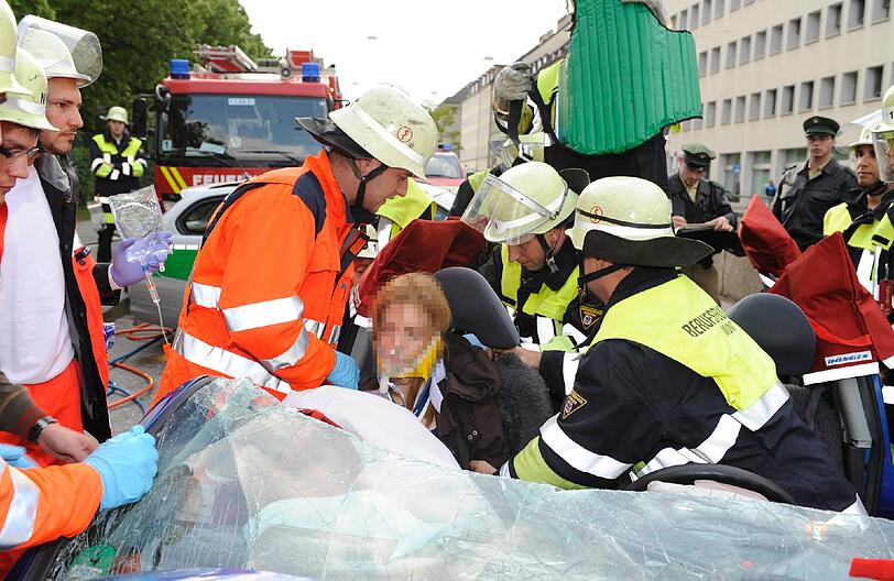 Die Feuerwehr befreit das Unfallopfer aus dem völlig zerstörten Kleinwagen.