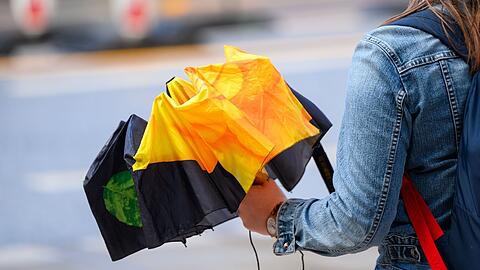 Eine Frau hält einen Regenschirm in der Hand.