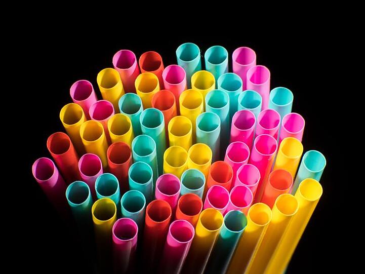 Trinkhalme aus Plastik liegen auf einem Tisch.