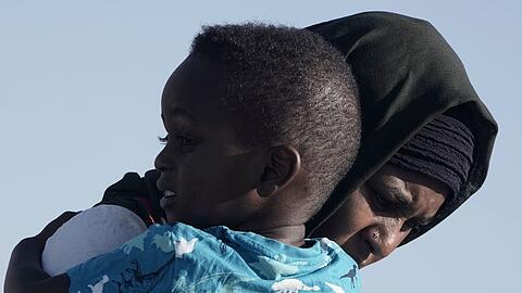 Eine Mutter mit Kind auf der Flucht: Im Sudan ist ein lange schwelender Machtkampf Mitte April gewaltsam eskaliert.