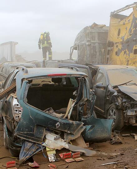 Feuerwehrleute sind am Freitag auf der Autobahn A19 bei Kavelstorf in der Nähe von Rostock bei einer Massenkarambolage im Einsatz. Bei einem Sandsturm fuhren in beiden Fahrtrichtungen Dutzende Fahrzeuge und LKW ineinander und brannten teilweise aus.