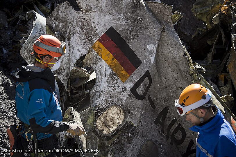 Die Einsatzkräfte bergen mit Atemschutzmasken größere Teile des zerschellten A320 der Germanwings.