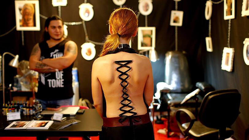 Bei einem Korsett-Piercing wird durch die am Rücken gepiercten Ringe ein Band geschnürt.