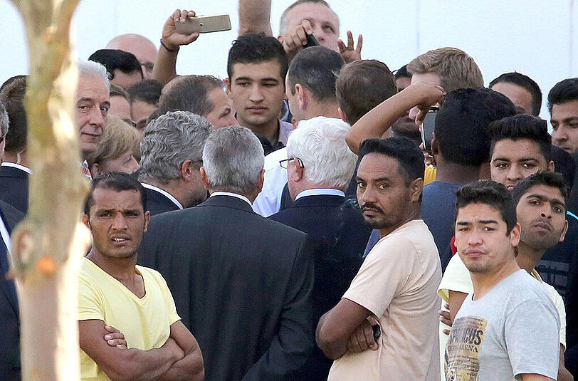 Umringt von Flüchtlingen und DRK-Funktionären besucht Bundeskanzlerin Angela Merkel die Flüchtlingsunterkunft in Heidenau.