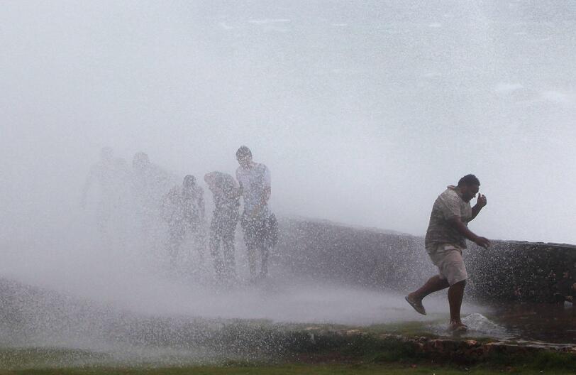 Eine riesige Welle schlägt an die Promenade in Santo Domingo (Dominikanische Republik). Die Menschen fliehen vor den Wassermassen.