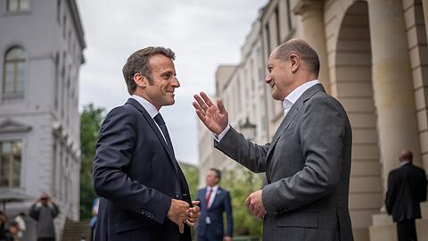 Bundeskanzler Olaf Scholz (SPD, r) begrüßt Emmanuel Macron, Präsident von Frankreich, vor einem gemeinsamen Abendessen zum Restaurant „Kochzimmer“ in Potsdam.
