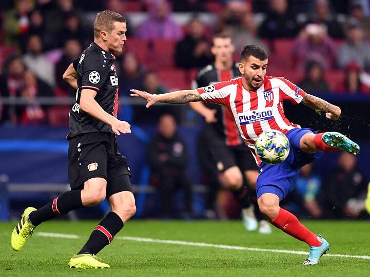 Leverkusens Lars Bender (l) nimmt Anlauf auf Atléticos Angel Correa.