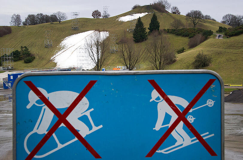 Ein Schild mit den Symbolen "Rodeln und Skifahren nicht gestattet." steht auf dem Olympiagelände in München (Archivbild)