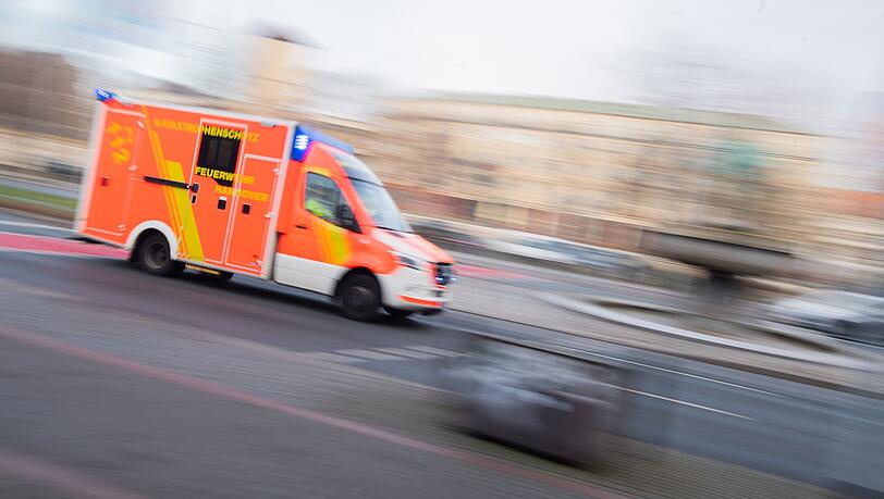 Ein Rettungswagen der Feuerwehr fährt mit Blaulicht durch die Innenstadt.