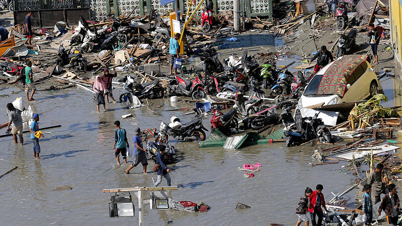 Pures Chaos: Menschen stehen in Trümmern nach den Erdbeben und dem Tsunami in Palu, Zentral-Sulawesi.