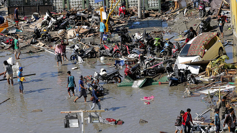 Pures Chaos: Menschen stehen in Trümmern nach den Erdbeben und dem Tsunami in Palu, Zentral-Sulawesi. Pures Chaos: Menschen stehen in Trümmern nach den Erdbeben und dem Tsunami in Palu, Zentral-Sulawesi.