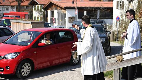 Bad Bayersoien: Autofahrer stehen Schlange, um ihre Osterkörbe beim "Drive-In" von Pfarrer Rudolf Scherer segnen zu lassen.