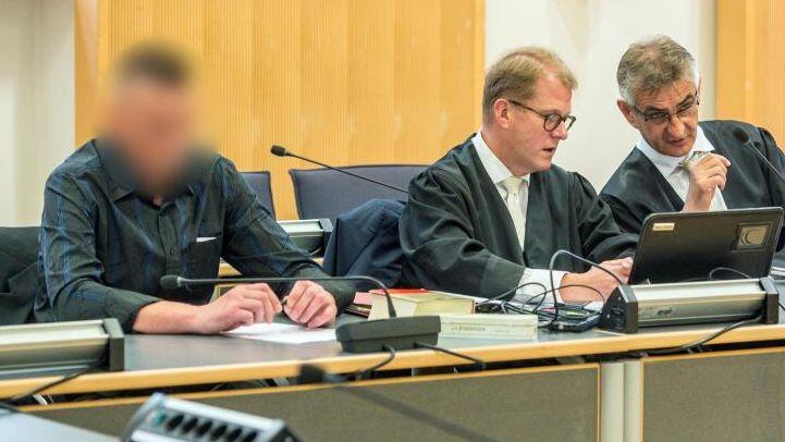 Der wegen Totschlags Angeklagte (l) sitzt im Verhandlungssaal des Landgerichts neben seinen Verteidigern. Foto: Armin Weigel