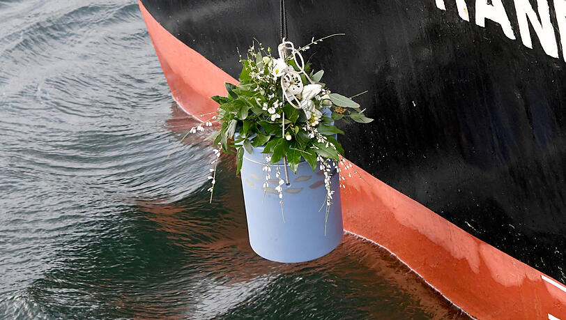 Eine Urne zur Seebestattung wird ins Wasser gelassen.