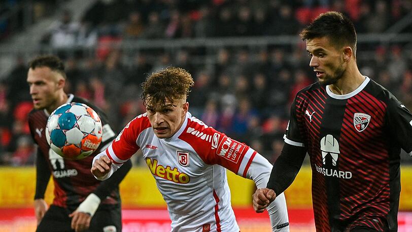 David Otto von Regensburg (M) und Visar Musliu (r) von Ingolstadt kämpfen um den Ball. David Otto von Regensburg (M) und Visar Musliu (r) von Ingolstadt kämpfen um den Ball.