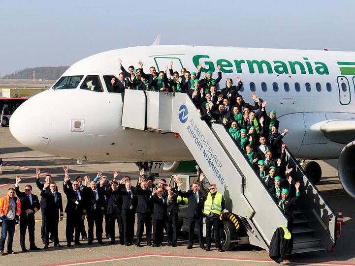Mitarbeiterinnen und Mitarbeiter der insolventen Fluggesellschaft Germania haben sich für ein Abschiedsfoto am Airport Nürnberg zusammengefunden.