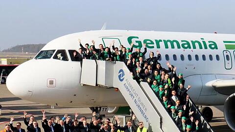 Mitarbeiterinnen und Mitarbeiter der insolventen Fluggesellschaft Germania haben sich für ein Abschiedsfoto am Airport Nürnberg zusammengefunden.
