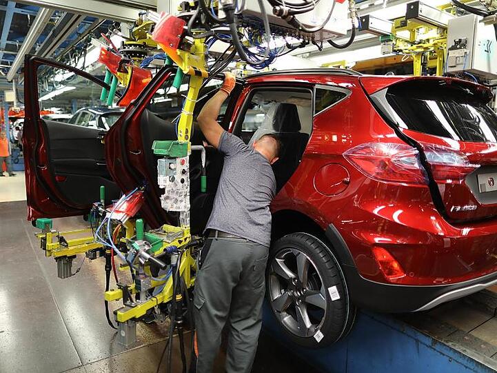 Ein Mitarbeiter baut im Ford-Werk in Köln eine Tür in einen Ford Fiesta ein.