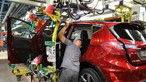 Ein Mitarbeiter baut im Ford-Werk in Köln eine Tür in einen Ford Fiesta ein.