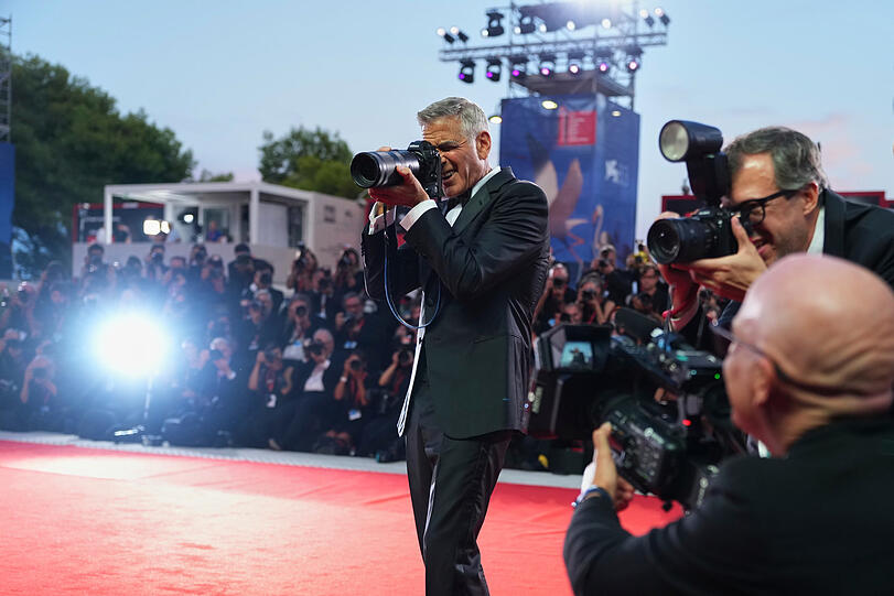 George Clooney greift zur Kamera eines Fotografen, nachdem er im Rahmen der 83. Ausgabe der Filmfestspiele von Venedig den Goldenen L&ouml;wen f&uuml;r sein Lebenswerk entgegengenommen hat.