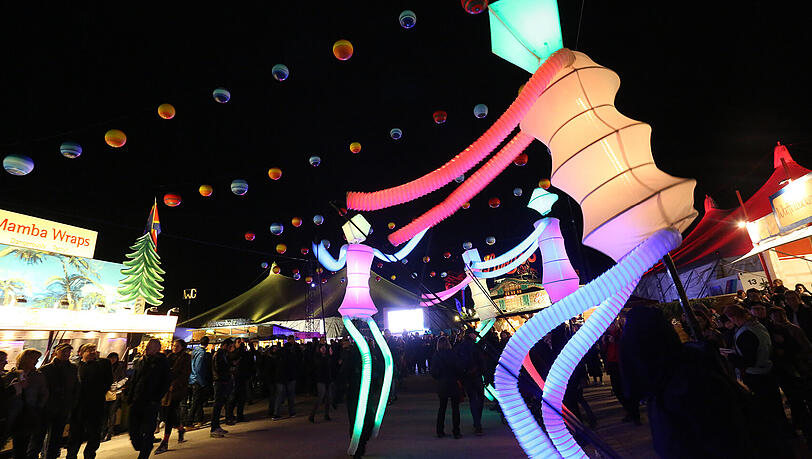 Leuchtende Walk-Acts unterwegs auf dem Festivalgelände.