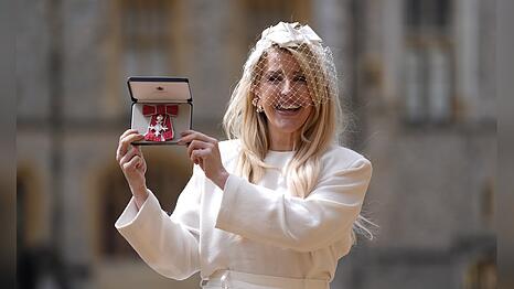 Ellie Goulding zeigt stolz ihren MBE-Orden.