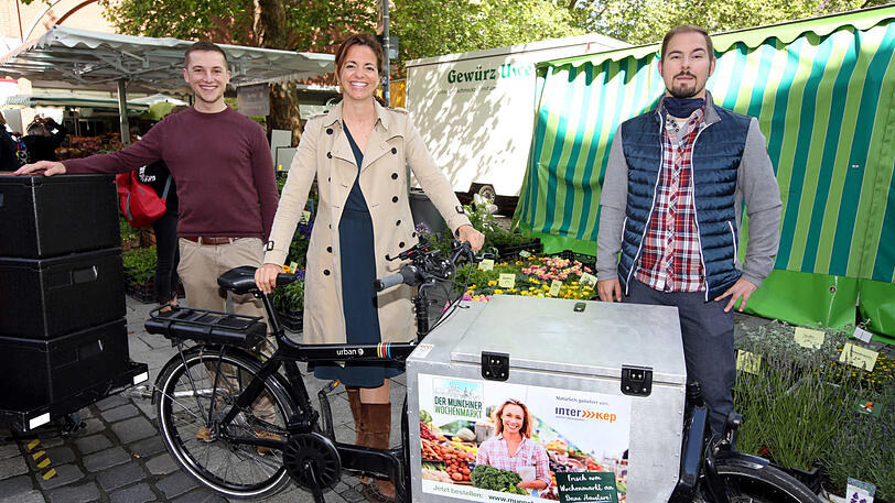 Kommunalreferentin Kristina Frank zeigt mit Julian Weritz (l.) und Matthias Steinberger, wie die Wochenmarktbestellungen geliefert werden.