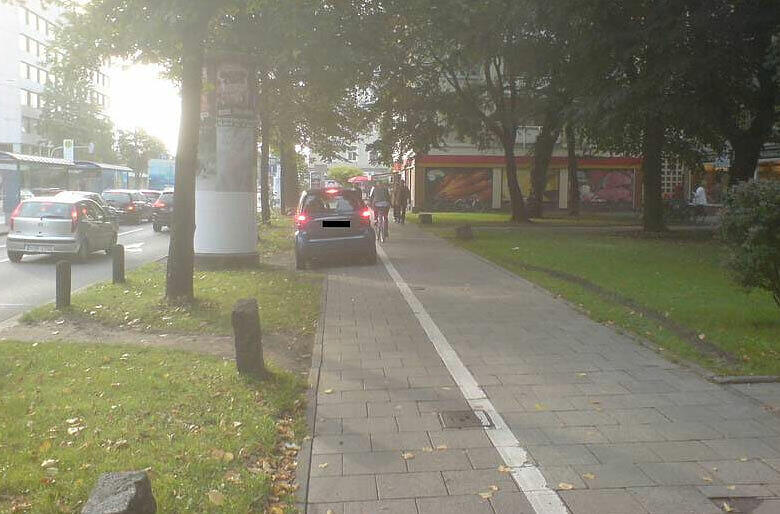 Leonrodplatz: Hier steht ein Kleinwagen auf dem Radweg - Radler müssen rechts ausweichen.