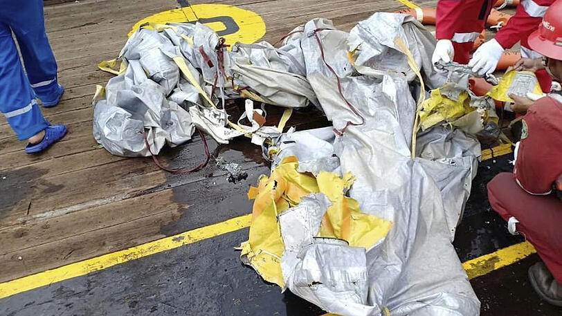 Rettungskräfte untersuchen Trümmerteile, die von der abgestürzten Lion-Air-Maschine stammen sollen.