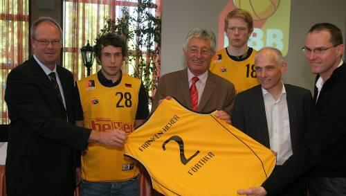 Gruppenbild mit Trikot: Bayerns Basketball-Boss Winfried Gintschel, Nationalspieler &bdquo;Hexer&ldquo; Basti Doreth, Sportbürgermeister Horst Förther, Nationalspieler Philipp Neumann, Brose-Baskets-Manager Wolfgang Heyder und Hexer-Trainer Alex Krüger (von links).