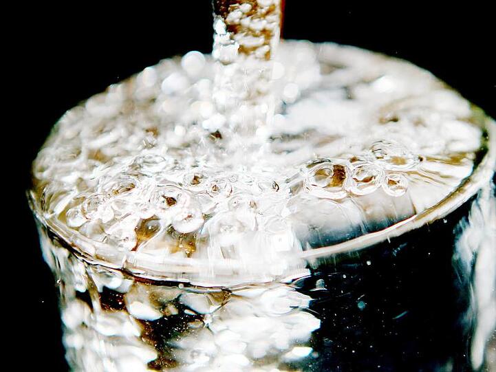 Ein Glas läuft voll Trinkwasser. Foto: Oliver Berg/Archivbild